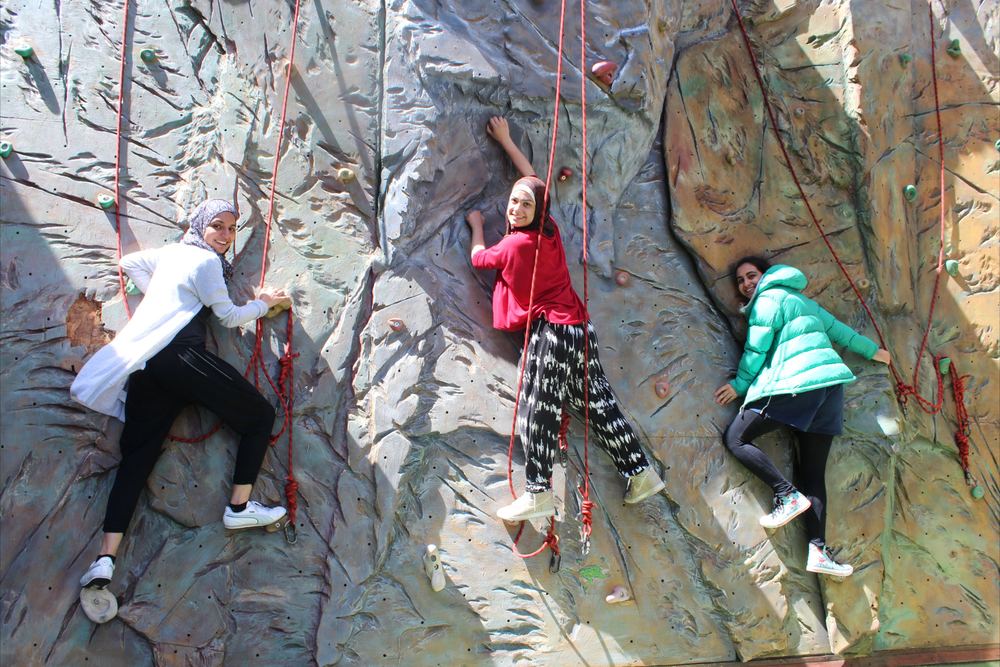 Members on the climbing wall at camp