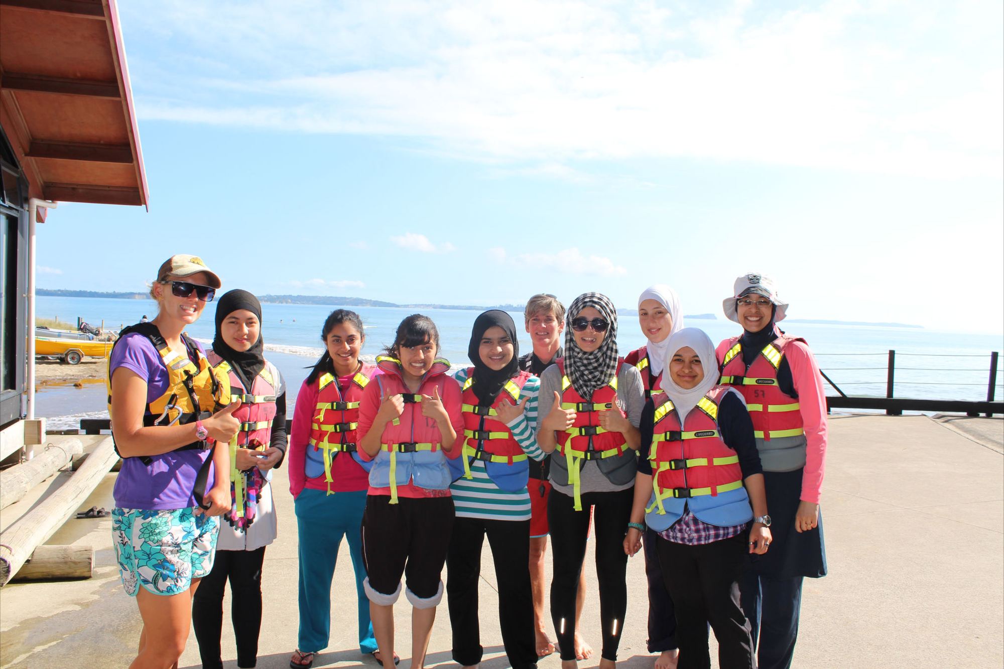 YMWA members in life jackets on the beach at camp