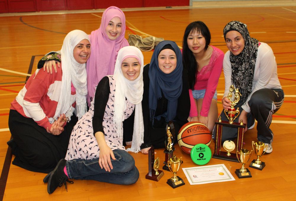 Members with trophies after a basketball tournament